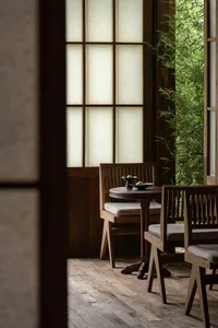 A warm and inviting dining area with wooden chairs and tables arranged around a central table, creating a comfortable seating arrangement