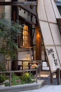 Cozy dining space with a wooden exterior, chairs, table, and bottles, conveying a warm and inviting ambiance