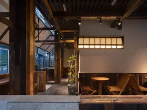 木質牆面、椅子與盆栽的溫馨餐廳內部，營造溫暖親切的氛圍