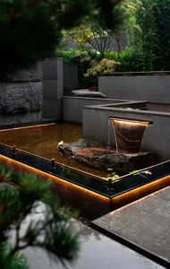 a serene outdoor space with a stone fountain surrounded by lush greenery and potted plants, featuring a bird perched nearby
