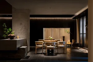 A wooden table in a restaurant dining area surrounded by chairs, set for dinner service, creating a warm and inviting atmosphere