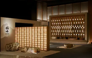 A modern room with a large wooden wall featuring small squares and several rocks placed in front, creating a bright and stylish atmosphere
