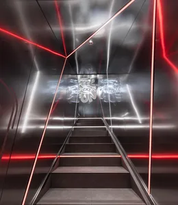 A modern metal staircase in a contemporary space with red lighting and a dark background