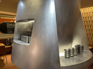 Industrial kitchen with a large silver countertop, multiple canisters, and a focus on organization and functionality