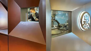 Industrial kitchen with two sections separated by a wall, featuring a counter, appliances, and cooking supplies