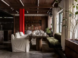 Modern dining and living space with a dining table, chairs, and a couch, set up for a meal or gathering