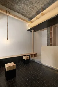 Cozy room with wooden floors and walls, featuring two benches and three stools, creating a warm atmosphere