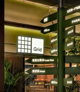 An indoor space with signs and directions displayed on a green pole, written in English and Chinese, creating an organized and informative atmosphere for visitors