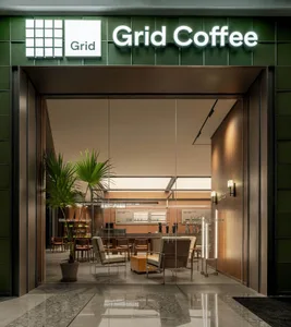 Cozy modern living area with a glass door leading to a patio, chairs around a dining table, and a kitchen area with a sink and refrigerator
