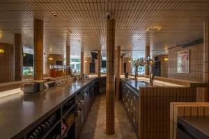 Modern bar area with brick walls, beer taps, and bottles on the countertop