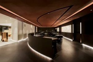 A spacious modern restaurant with tables and chairs arranged throughout the dining area, creating a welcoming atmosphere