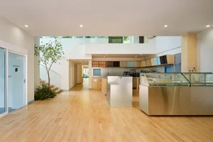 Open modern kitchen and dining area with stainless steel appliances, natural light, and a clean contemporary design