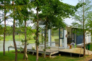 Modern house with a wooden exterior, large windows, and a natural ambiance with trees outside