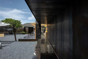 A large open interior space with a concrete floor, chairs, and people in various positions, with a mix of photo and rendered design elements