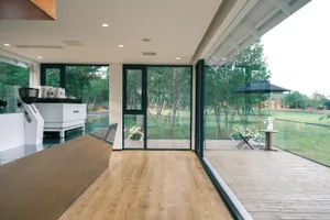 Open living area with hardwood flooring, modern design, potted plants, and decorative vases