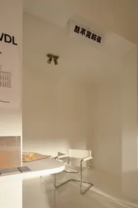 Empty white room with a table and two chairs, surrounded by white walls and a minimalist atmosphere