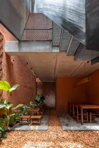 Warm and inviting dining space with brick walls, tables, chairs, and potted plants