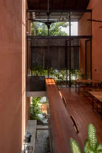 Warm and inviting restaurant interior with a wooden deck, glass wall, and multiple dining tables and chairs
