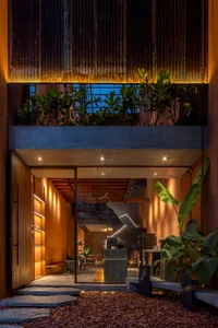 A cozy living space with a dining table, chairs, potted plants, vases, and a clock, creating a warm and inviting atmosphere