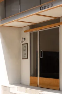 Cozy dimly lit interior with a modern glass door and wooden frame, featuring a bedroom with a bed
