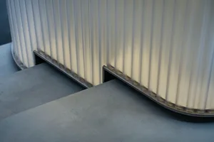 A functional staircase with a metal railing and gray concrete steps in a building with a somewhat industrial design