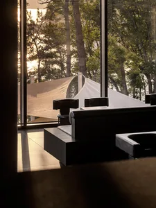 A well-lit living space with a large black chair in front of a window, accompanied by a smaller chair, creating a comfortable and inviting atmosphere