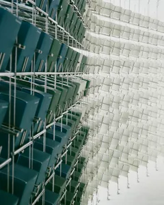 A large event space with multiple metal chairs in various positions, creating a sense of depth and complexity, under well-lit conditions