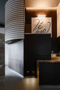 Elegant interior space with wooden walls and floors, featuring two staircases with metal railings and a warm atmosphere