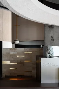 Dining room with a large stone wall, two statues, a fireplace, and a modern interior design