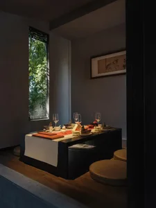 A formal dining area with a wooden table and chairs, set for dinner with wine glasses, creating an elegant atmosphere