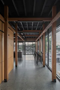 Warm and inviting restaurant interior with wooden beams, concrete flooring, and multiple tables and chairs