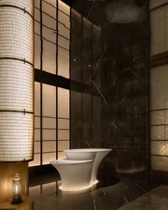 Modern bathroom with a white toilet, black marble countertop, and natural light from a large window, featuring two lamps and a sink