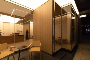 Warm and inviting living space with wooden walls and floors, featuring a dining table, chairs, and a potted plant