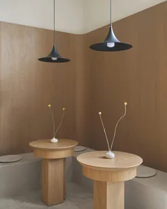 A warm and inviting room with two wooden tables, three vases, and hardwood floor, set against wood walls