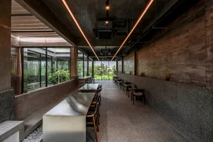 A modern dining area with a large silver table surrounded by chairs, well-lit and inviting