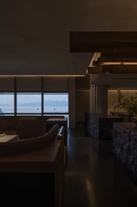 Coastal dining space with a large window offering ocean views, comfortable seating, and a bar area