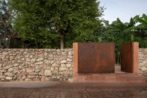 A rustic stone wall in front of a tree, with natural surroundings and a focus on the stone texture