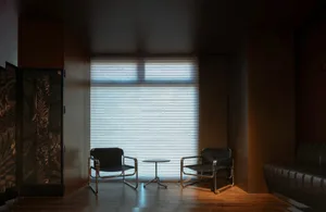 A cozy dining area with two black chairs and a table in front of a window, creating a warm and inviting space