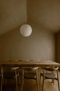 A calm and inviting dining area with a wooden table surrounded by chairs, part of a larger living space