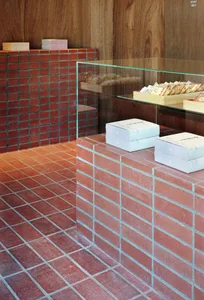 A cozy room with a brick wall and three white boxes on it, suggesting a warm and inviting atmosphere