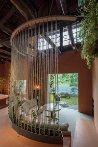 A modern living space with a canopy bed, two chairs, and a dining table, creating a cozy atmosphere