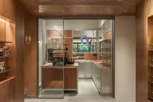 Modern kitchen with two sinks, a refrigerator, oven, and microwave, featuring wooden cabinets and countertops