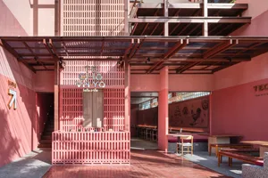 Cozy modern restaurant with pink walls, a large window, and chairs around a dining table