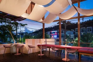 An open-air restaurant with multiple dining tables and chairs, creating a welcoming atmosphere for social gatherings and family dinners