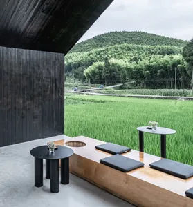 A relaxed outdoor patio area with a wooden table and three black chairs, perfect for casual dining or conversation