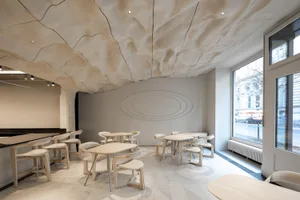 Modern restaurant interior with multiple tables and chairs, providing ample seating options for guests