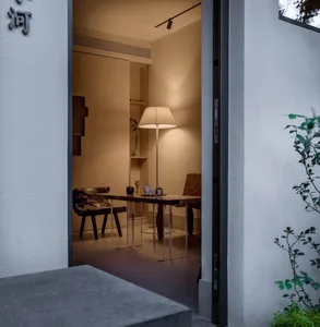 A well-lit modern dining space with a table, chairs, and a lamp, featuring clean lines and simple furnishings