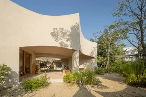 A modern house with a curved wall and large window, featuring clean lines and minimalistic elements, with ample natural light and a bright atmosphere