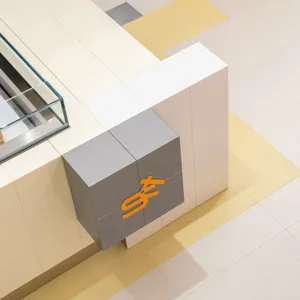 A modern interior design featuring a large white wall with a gray concrete block structure in front of it