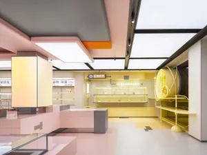 A modern restaurant with concrete walls, tables, chairs, and counters, featuring a warm and inviting atmosphere with well-thought-out lighting